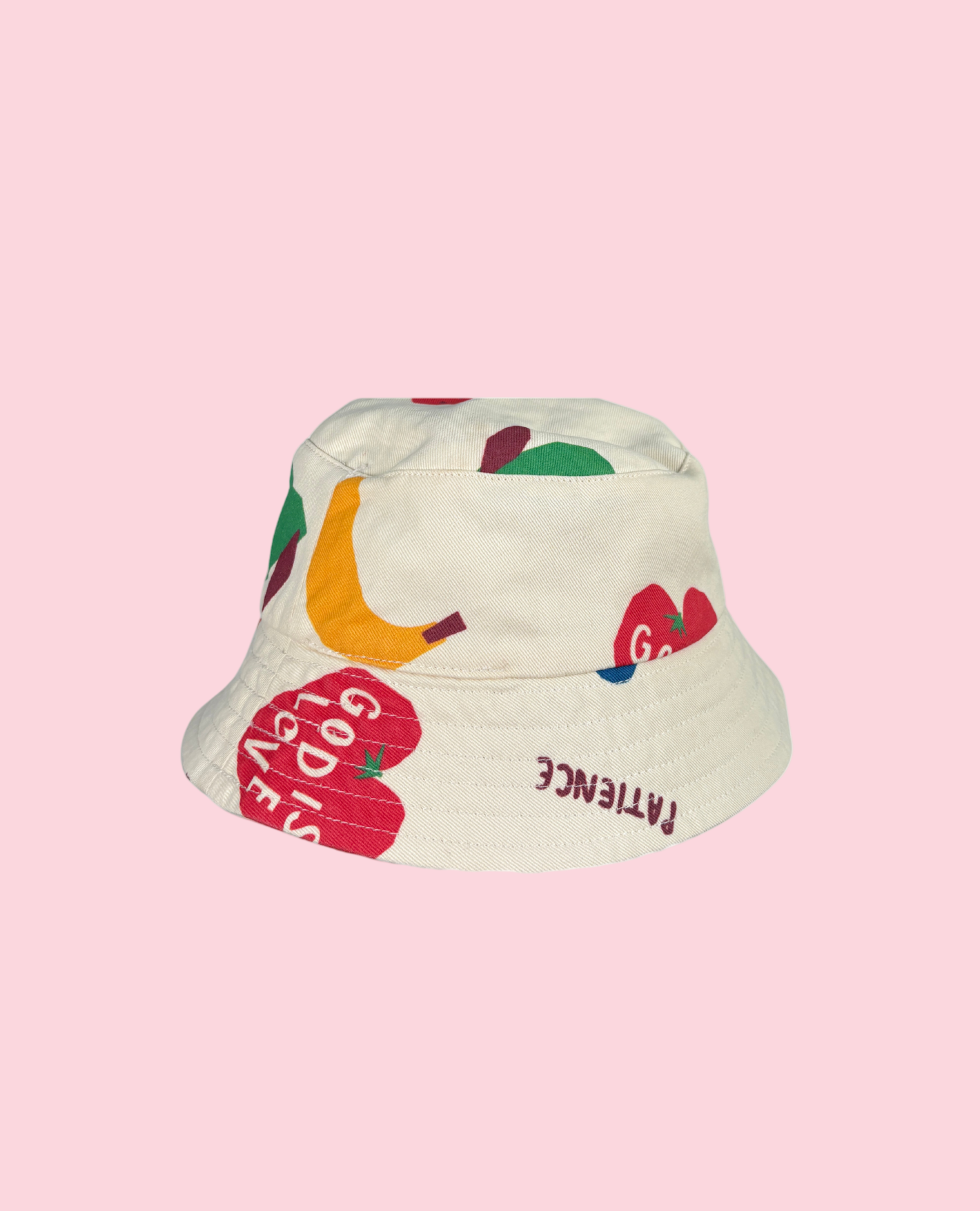Bucket hat with colorful fruit designs on a pink background